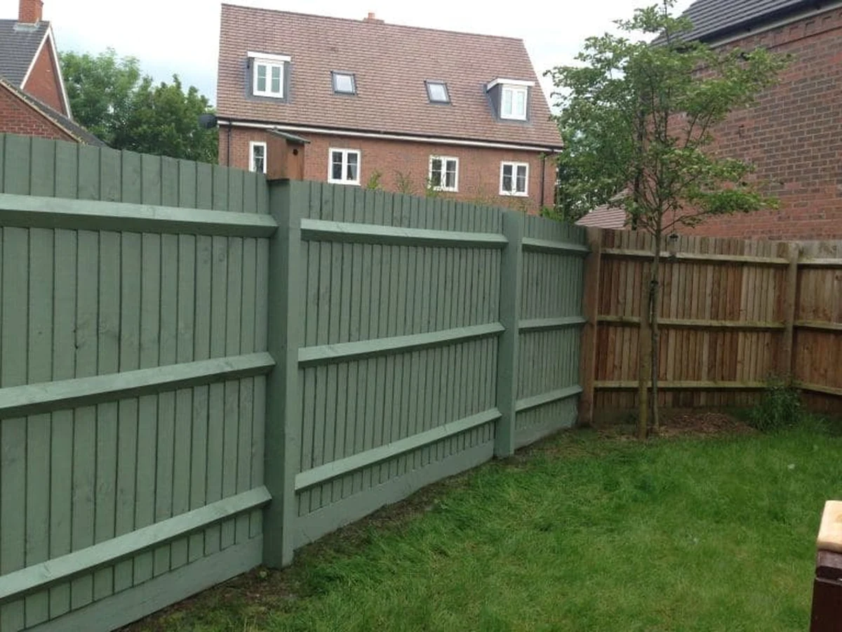 Green wooden fence painted in Haywards Heath