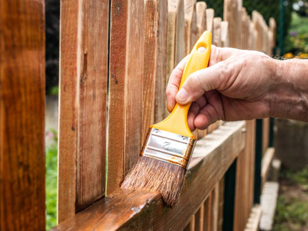 Hand brush applying fence paint in Haywards Heath